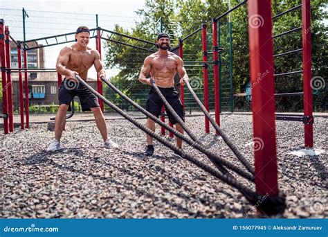 Men Work Hard With Rope At Street Gym Yard Strength And Motivation