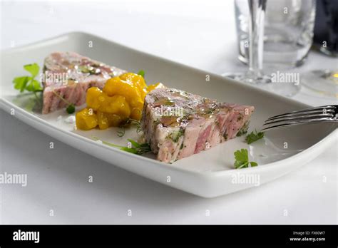 Ham hock & trotter terrine with piccalilli Stock Photo - Alamy