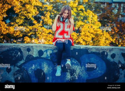 Jeune belle fille blonde écoutant de la musique dans un parc du parc de la ville Technologie