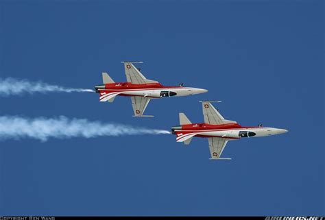 Two Red And White Jets Flying In The Sky