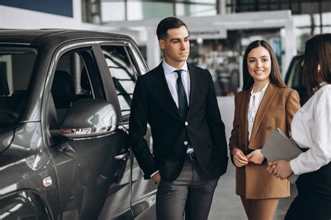 Jovem Casal Escolhendo Um Carro Em Uma Sala De Exposições Foto Grátis