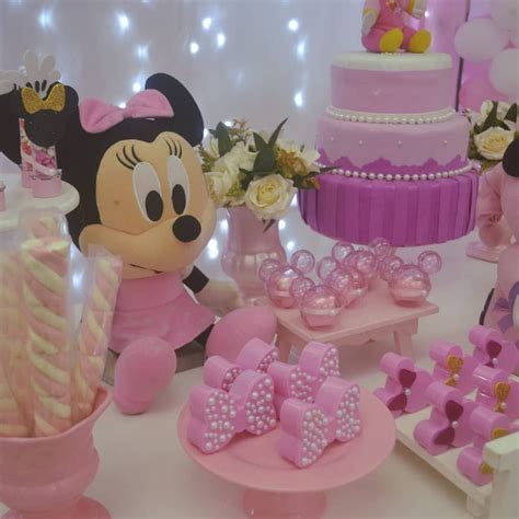 A Table Topped With Lots Of Cakes And Minnie Mouse Figurines