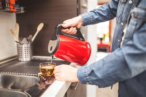 Premium Photo Close Up Focus On Male Hand Holding Kettle And Pouring