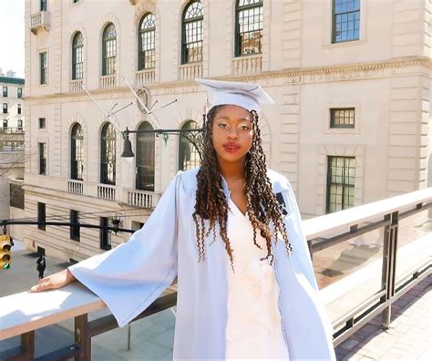 a woman wearing a white graduation gown and cap