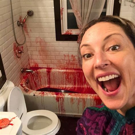 A Woman With Her Mouth Open Standing In Front Of A Bathtub Full Of Blood