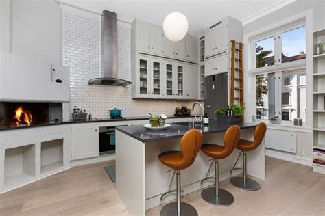 A Kitchen With Two Bar Stools Next To An Oven