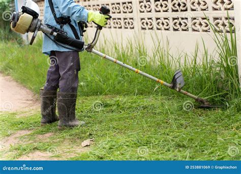 Gardening With An Electric Brush Cutter At Home Garden Worker Using