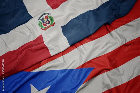 waving colorful flag of puerto rico and national flag of dominican ...