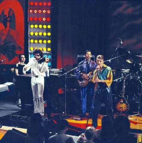 A Group Of People Standing On Top Of A Stage With Musical Instruments