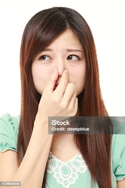 Japanese Woman Holding Her Nose Because Of A Bad Smell Stock Photo