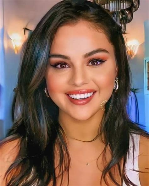 a close up of a person wearing a white shirt and smiling at the camera ...