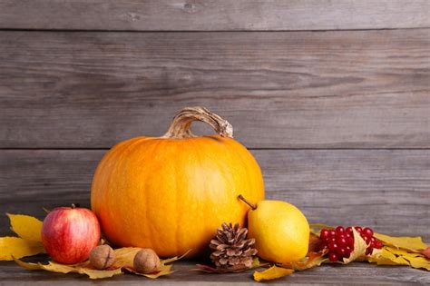 Premium Photo Orange Pumpkin With Leaves And Vegetables On Grey