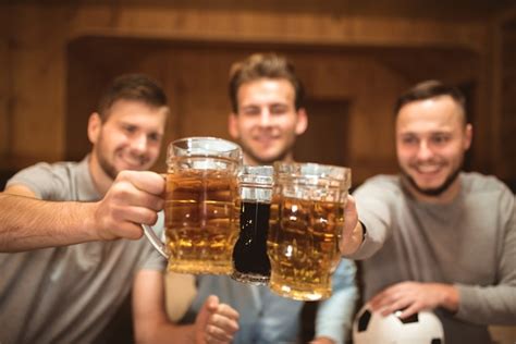 O Sorriso De Amigos Felizes Brindando Uma Cerveja Foto Premium