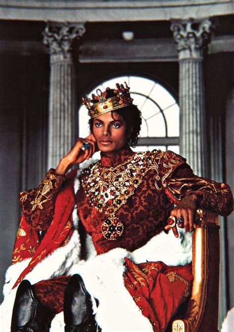 A Man Dressed In An Elaborate Costume Sitting On A Chair With His Hand