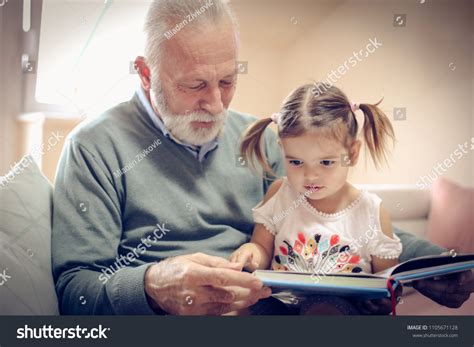 Happy Grandfather Granddaughter Reading Book Together Stock Photo