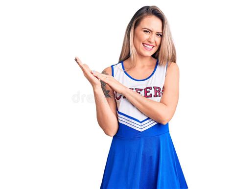 Young Beautiful Blonde Woman Wearing Cheerleader Uniform Clapping And