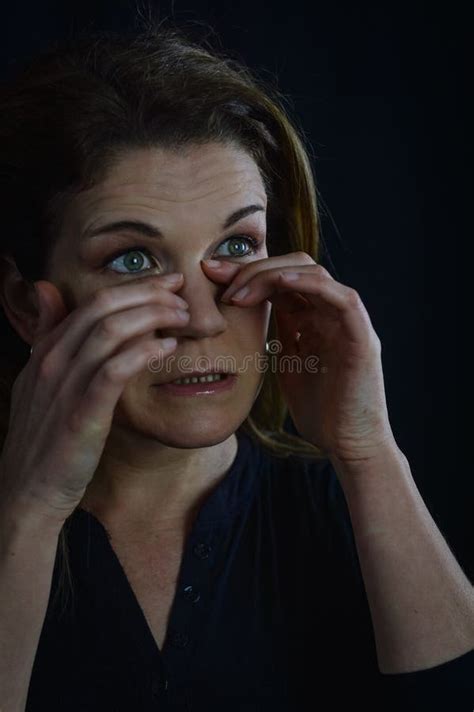 Portrait Of A Beautiful Blonde Woman Who Is Tired Rubs Her Eyes Trying Not To Ruin Her Makeup