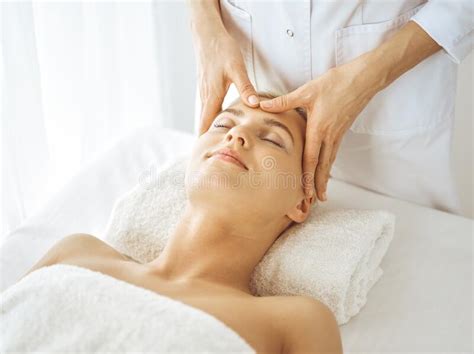Beautiful Blonde Woman Enjoying Facial Massage With Closed Eyes Relaxing Treatment In Medicine