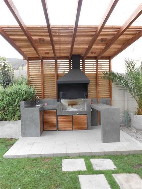 An Outdoor Kitchen With Grill And Seating Area