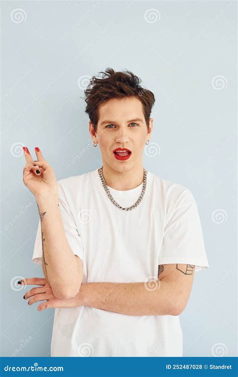 Un Joven Gay Está Parado En El Estudio Posando Para Una Cámara Labios De Lápiz Labial Rojo Foto
