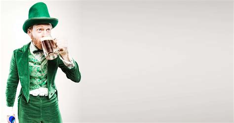 Download A Man In A Green Outfit Drinking A Beer | Wallpapers.com