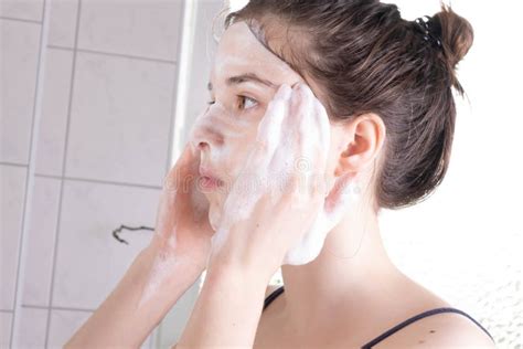 Girl In The Bathroom Strongly Soaped Her Face With Soap Stock Photo