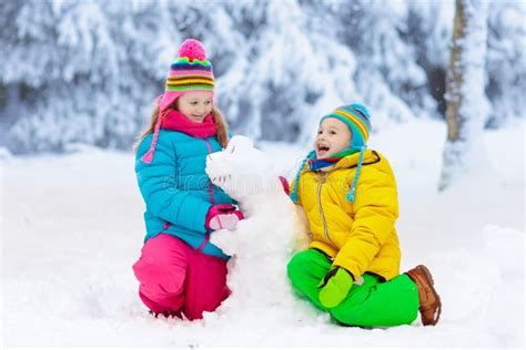 做冬天雪人的孩子 在雪的儿童游戏 库存图片 图片 包括有 童年 外面 愉快 帽子 盐鲱鱼 喜悦 127962733