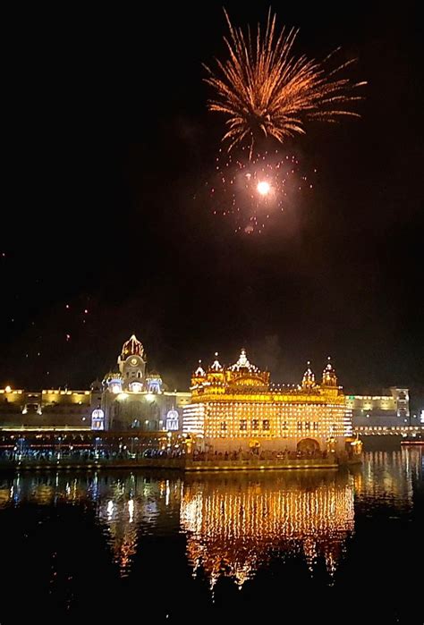 Devotees watch fireworks explode over the illuminated Golden Temple.