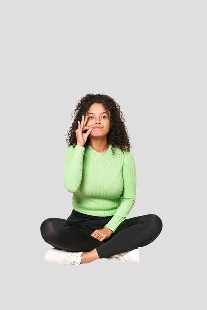 Jeune Femme Bouclée Afro américaine Assise Sur Le Sol Isolée Photo