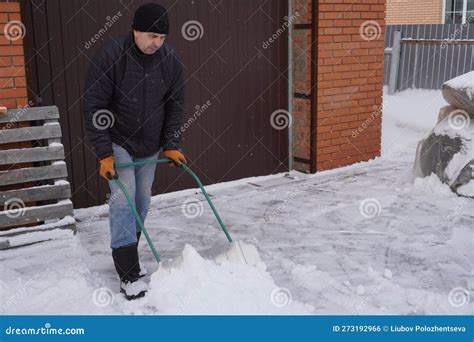 A Man Cleans Snow In The Winter In The Courtyard Of The House Stock