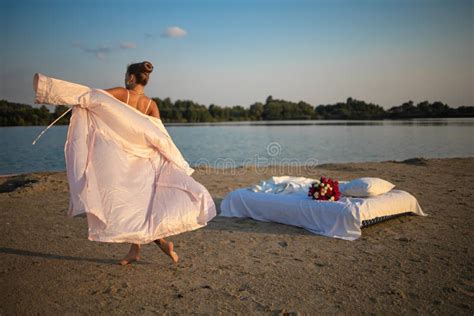 Blonde Woman In Lingerie Holds Flower Bouquet On Beach At Sunset Stock Image Image Of Beach