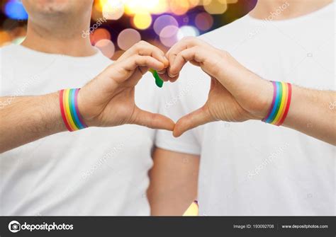 Gay Couple With Rainbow Wristbands And Hand Heart Stock Photo Syda