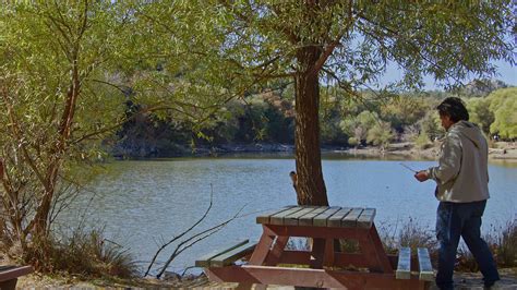 Old Man Sitting On Bench By The Lake And Looking At The Lake 14198535