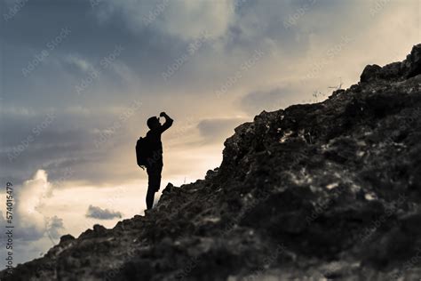 Man getting ready to climb up mountain looking up at the challenge ...