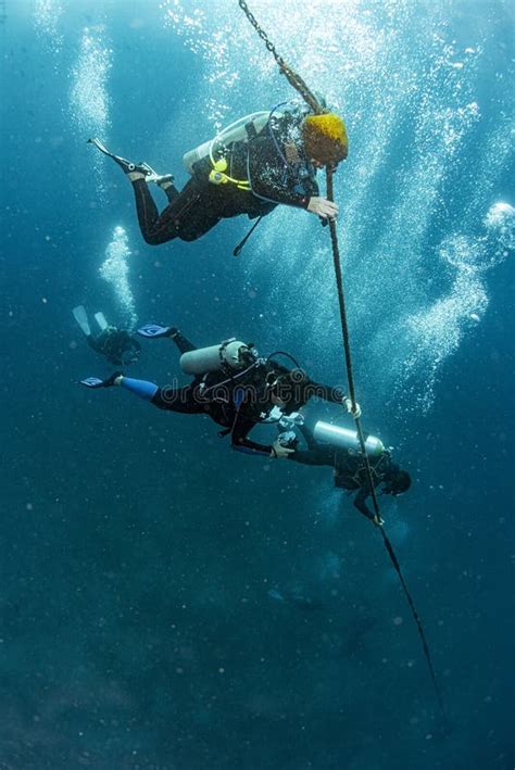 Scuba Diver Near Boat In Transaprent Waters Holding A Rope Stock Image