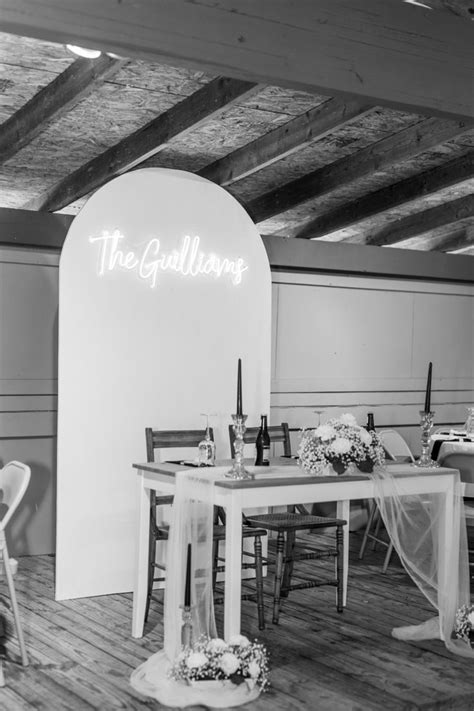 Sweetheart Table With Neon Sign And Wooden Arch