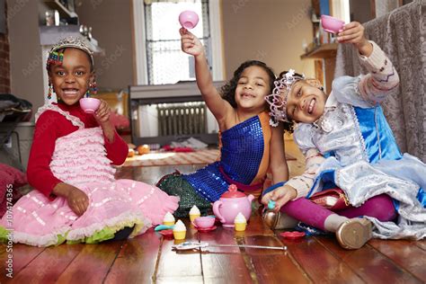 Girls playing dress-up and posing at tea party Stock Photo | Adobe Stock