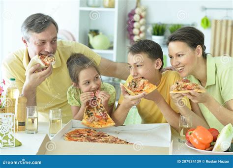 Retrato De Familia Feliz Comiendo Pizza Juntos Imagen De Archivo