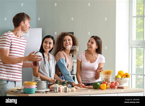 Happy Friends Cooking Together In Kitchen Stock Photo Alamy