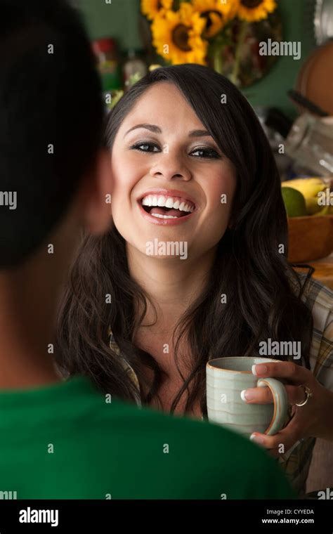 Beautiful Latina Woman At Table In Kitchen With Coffee Or Tea And Male Companion Stock Photo Alamy