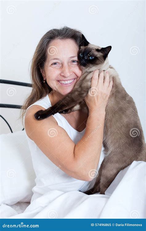 Mature Woman Sitting On Bed With Cat Stock Image Image Of Woman Aged 57496865