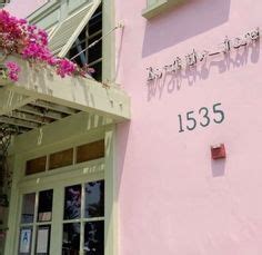 A Pink Building With Flowers Growing Out Of It S Windows And The Number