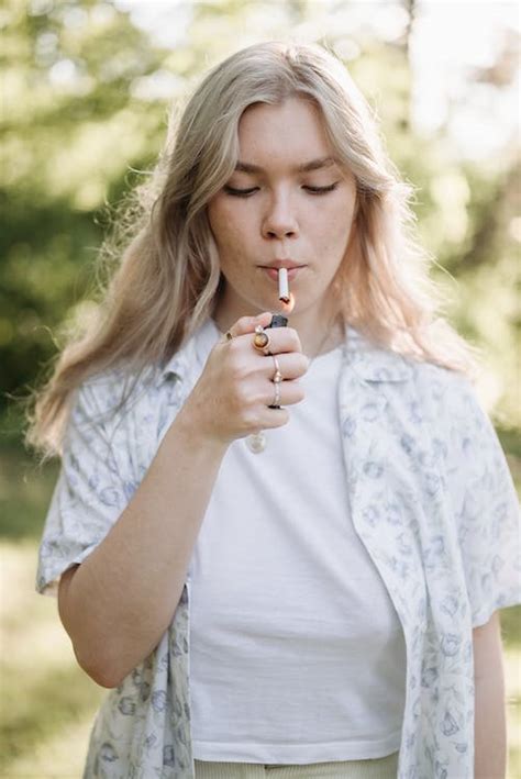 Woman in White Floral Shirt Smoking Cigarette · Free Stock Photo