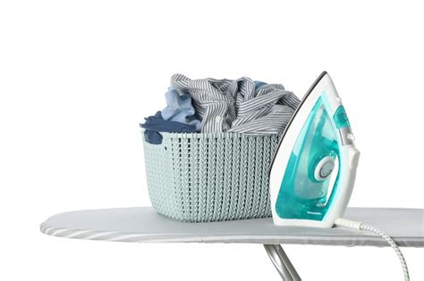 Premium Photo | Iron and basket with clothes on ironing board isolated on white