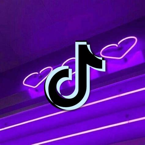 A Purple Neon Sign Hanging From The Side Of A Building With Heart