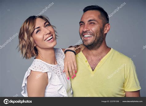 Happy couple in studio laughing over grey Stock Photo by ©pavel ...