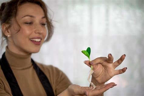 Retrato De Una Mujer Sonriente Sosteniendo Una Planta Foto Premium