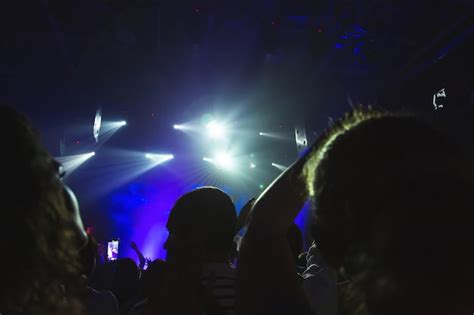 Silhuetas De Uma Multid O De Concertos Em Frente A Um Palco Iluminado