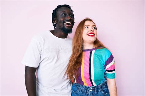 Interracial Couple Wearing Casual Clothes Looking Away To Side With