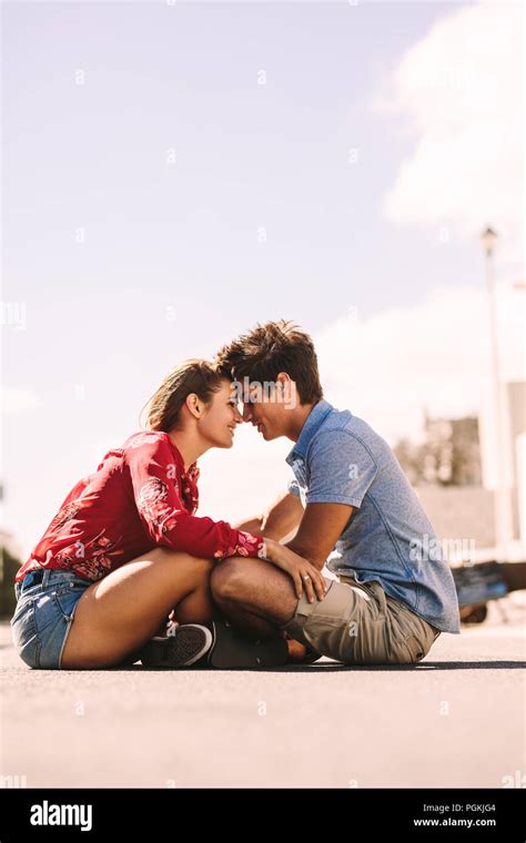 Romantic Couple Sitting On The Ground Together Touching Their Heads Man And Woman Sitting On